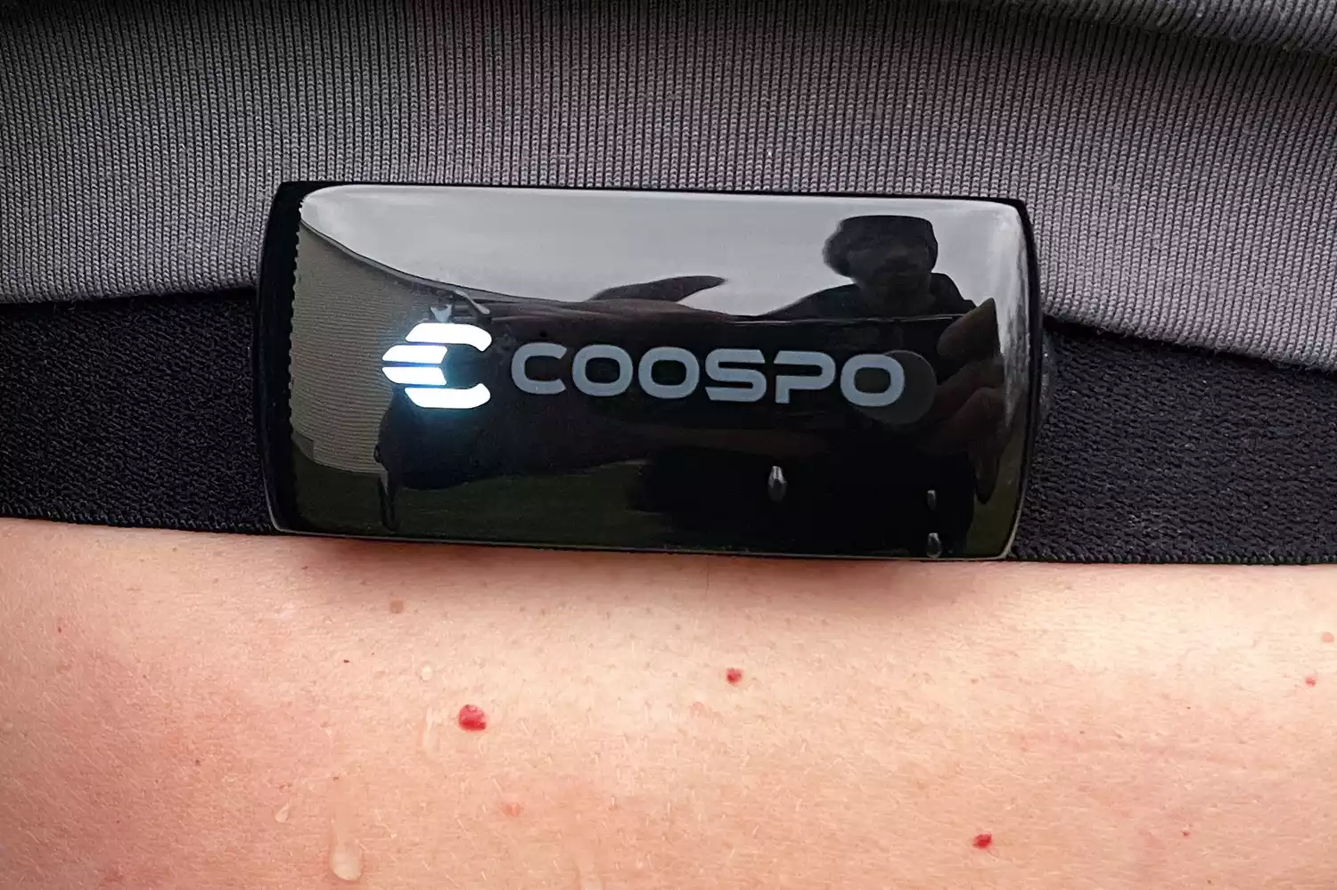 A person wearing a COOSPO chest strap heart rate monitor during a physical activity.