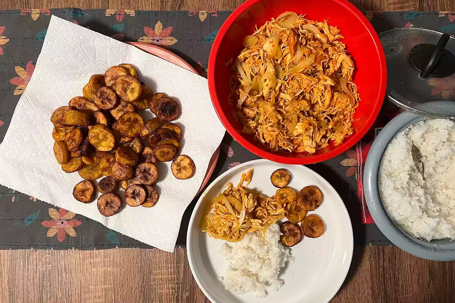 A top-down view of a colorful Ropa Vieja dish with rice and plantains.
