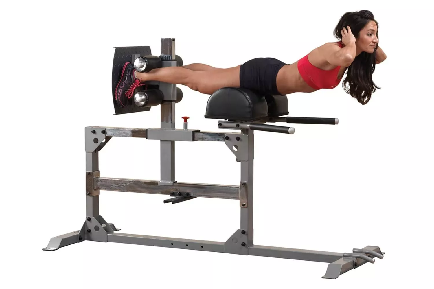 A woman performing a hyperextension exercise on a glute and hamstring machine to demonstrate posterior chain activation.