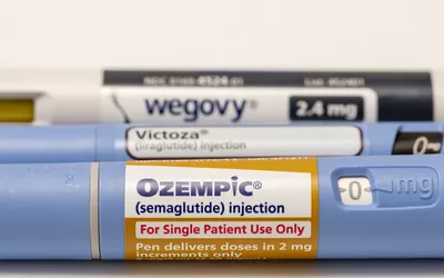 Three different injectable pens for weight management including Ozempic and Wegovy displayed on a white surface.