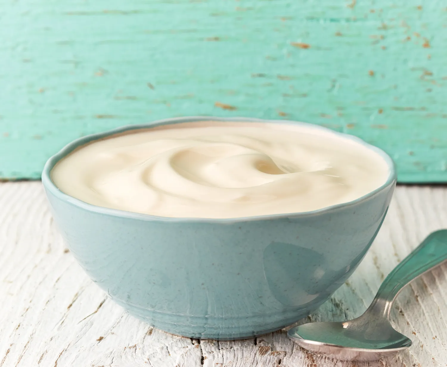 A close-up shot of creamy white Greek yogurt in a bowl.