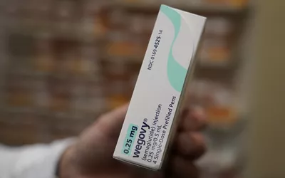 A hand holding a 0.25 mg Wegovy injection box, representing the starting dose for semaglutide therapy.