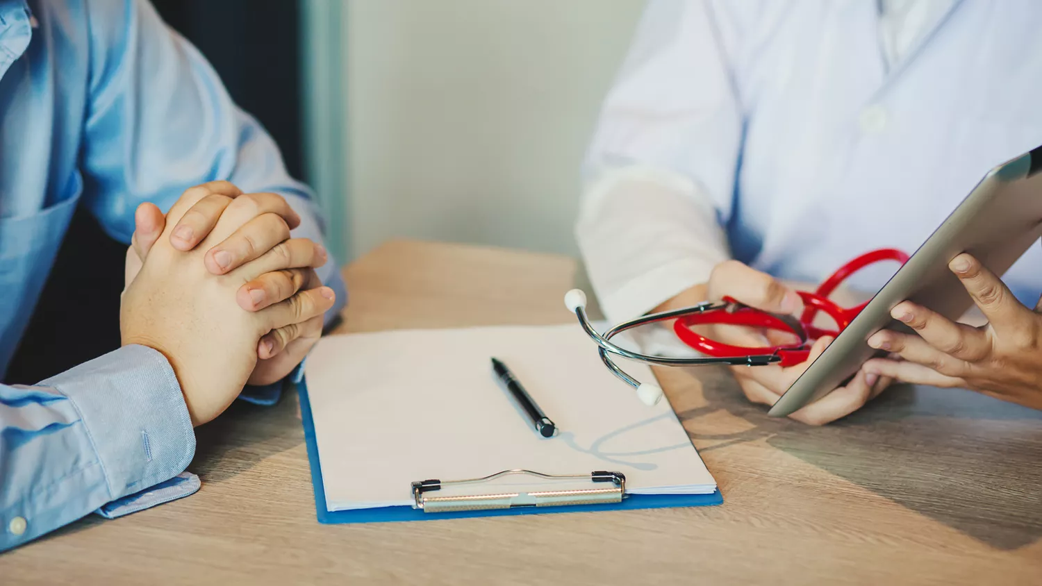 A patient and healthcare provider discussing medical results at a desk.