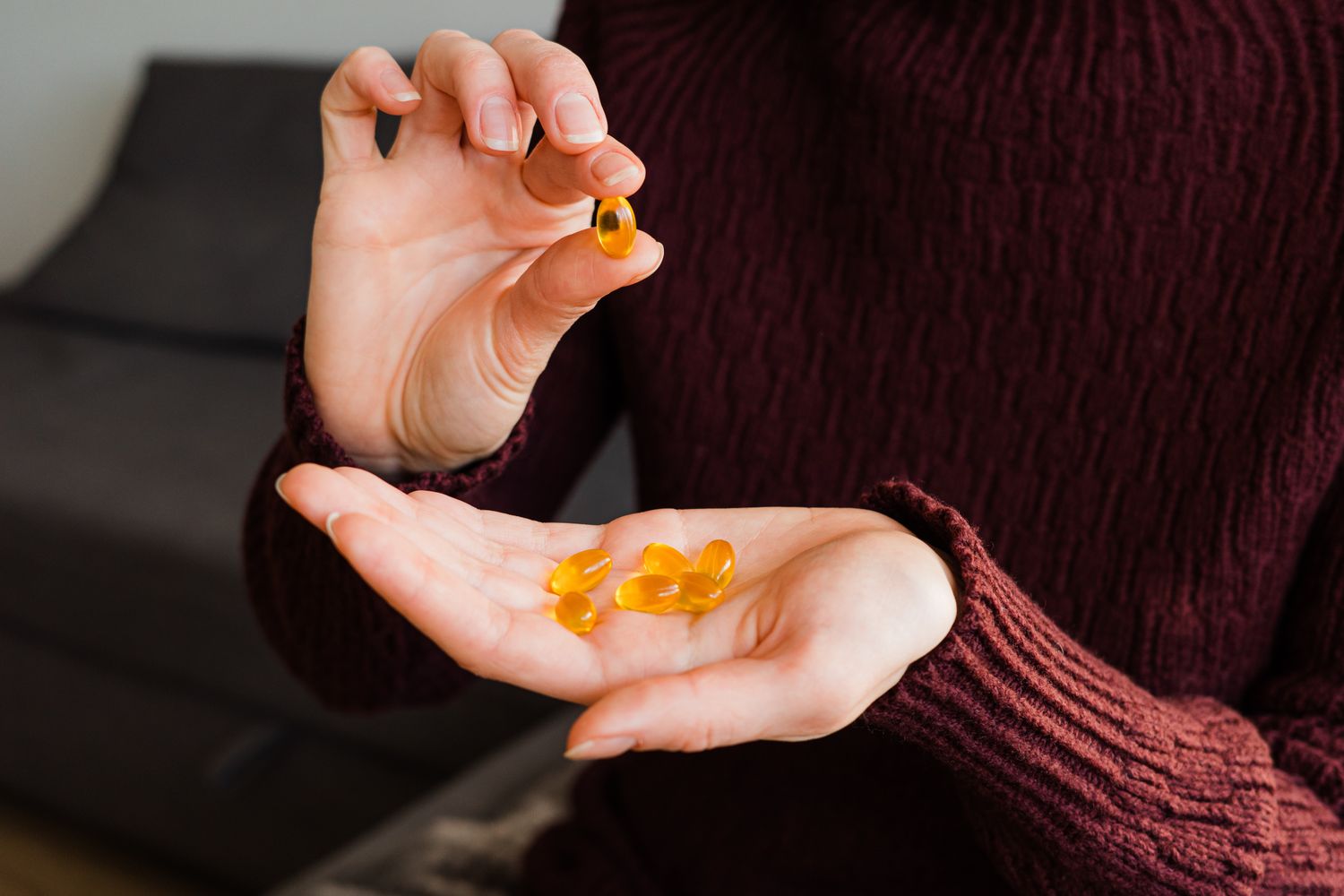 Close-up of a person holding yellow Vitamin D capsules, representing nutritional support for metabolic health.
