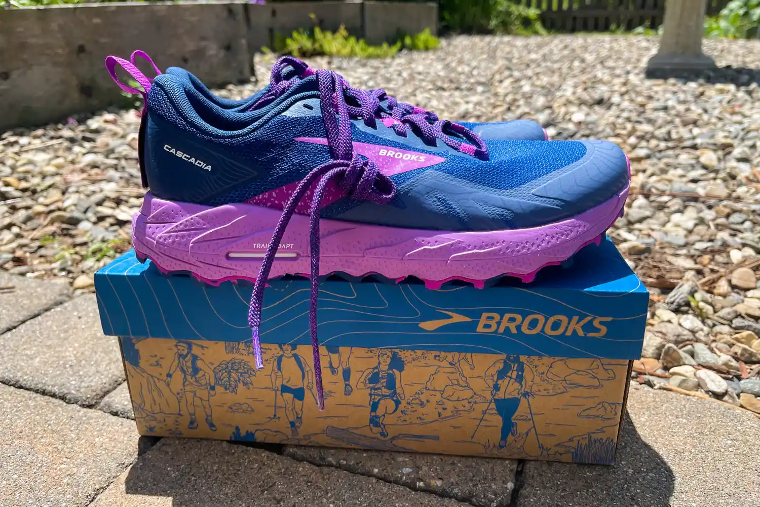 A pair of Brooks Cascadia trail running shoes featuring the Trail Adapt technology label.