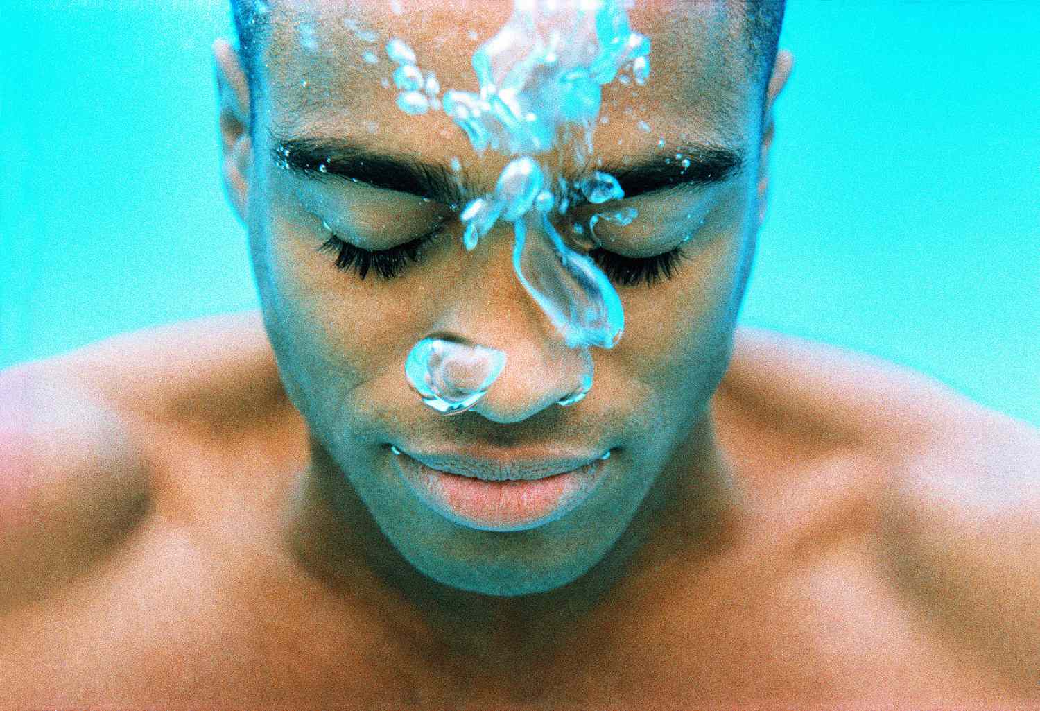 A person submerged in water being closely monitored by a safety partner.