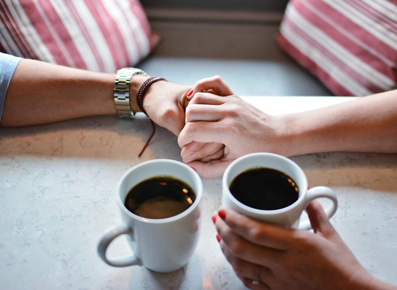 A coffee mug on a wooden table next to a window with soft morning light