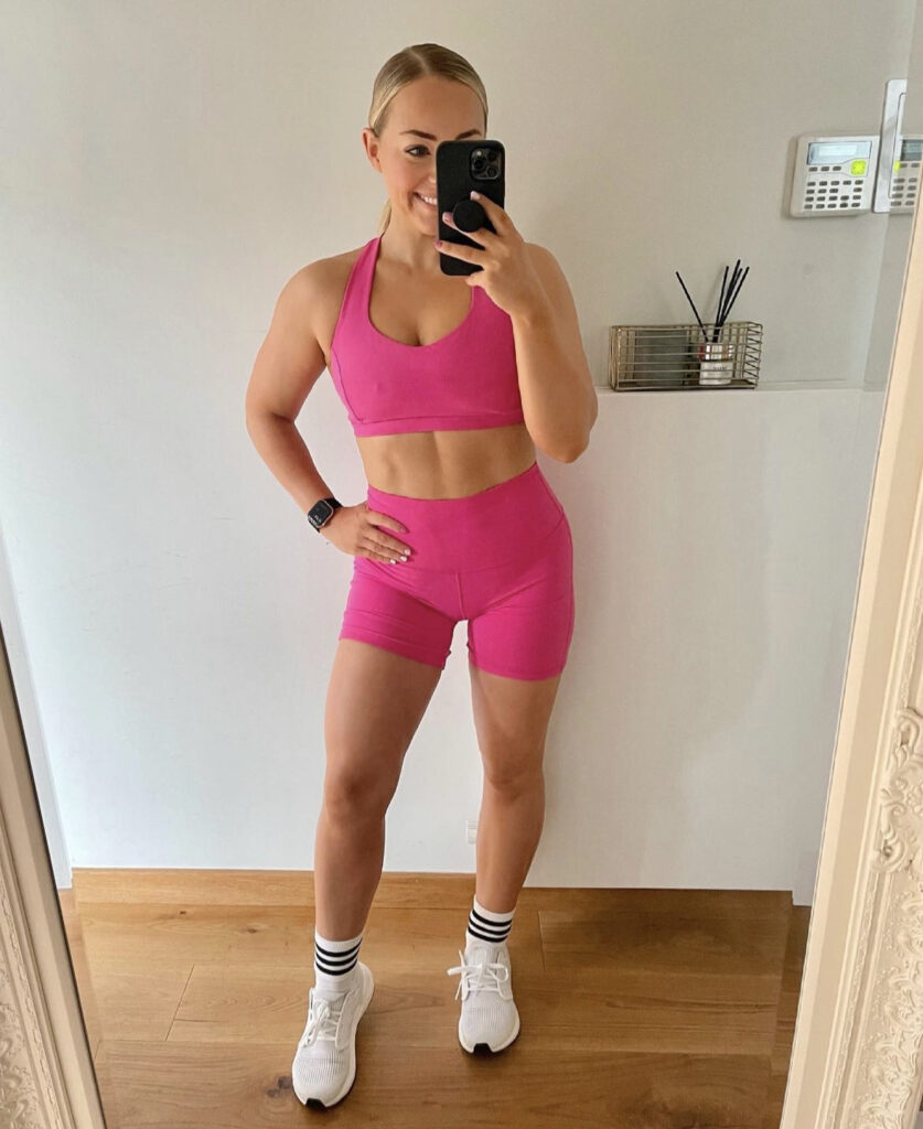 Alice Liveing performing a heavy compound lift in a professional gym setting.