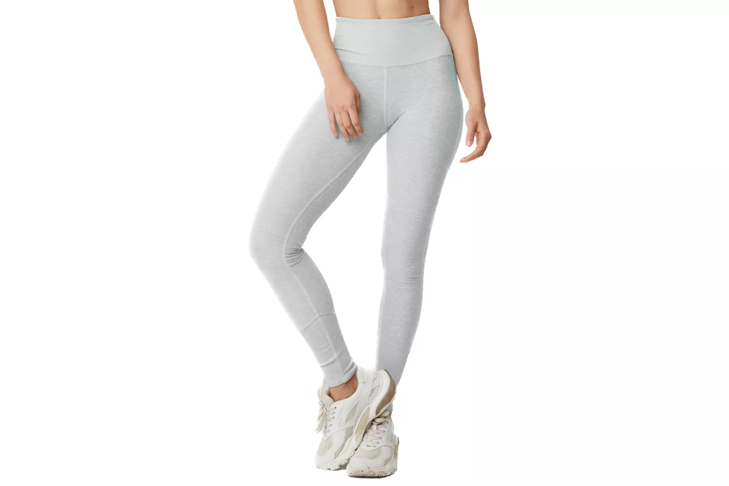 A woman modeling light gray high-waist leggings with a matte finish and athletic sneakers.