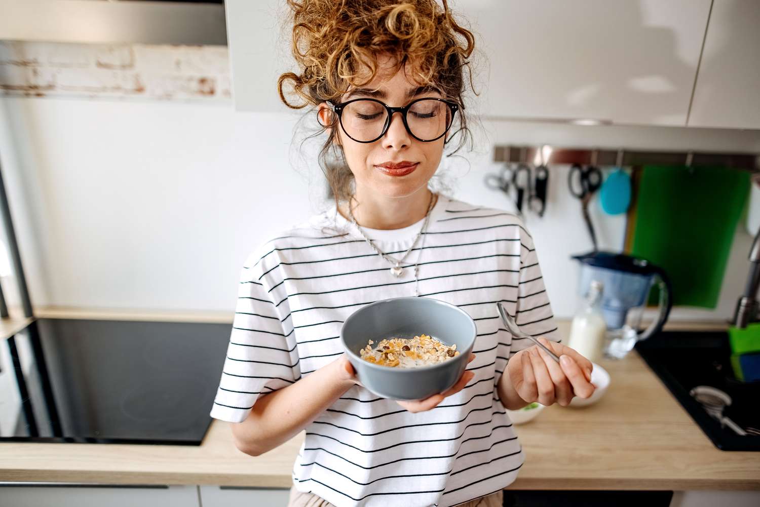 A woman enjoying a healthy breakfast bowl filled with berries and nuts.