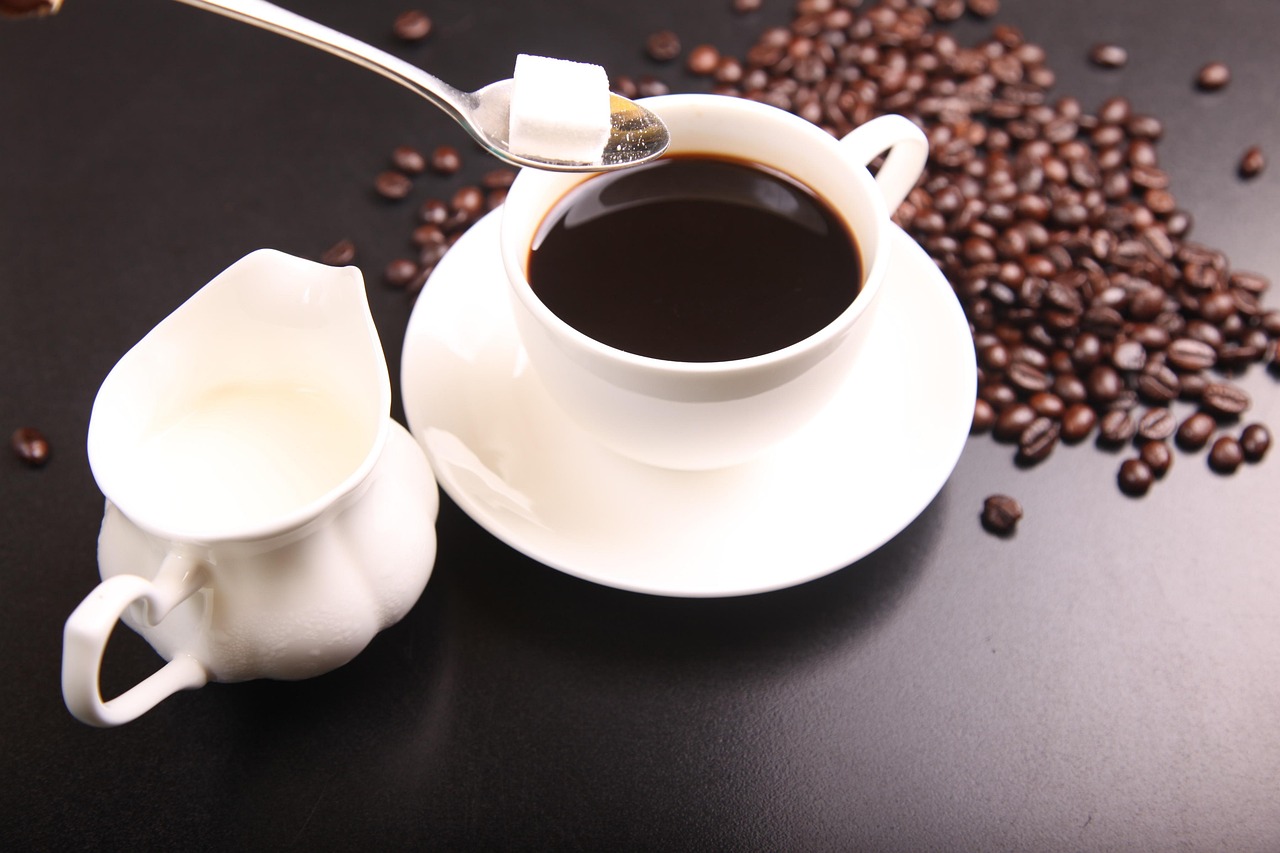 Hand using a battery-operated milk frother in a coffee mug