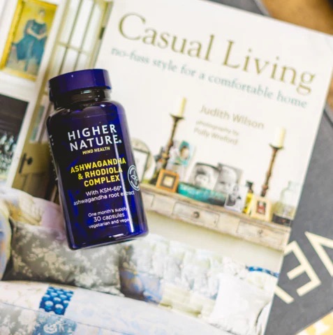 A variety of vitamins and minerals laid out on a minimalist countertop alongside a water carafe.