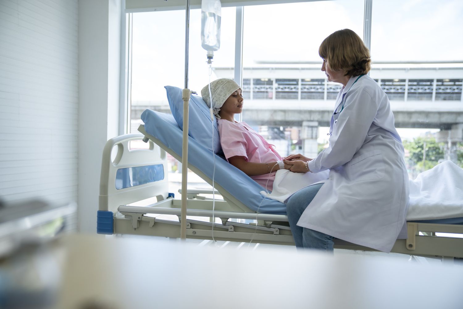 A doctor providing compassionate care to a patient in a hospital bed, emphasizing the clinical oversight of hypertension treatment.
