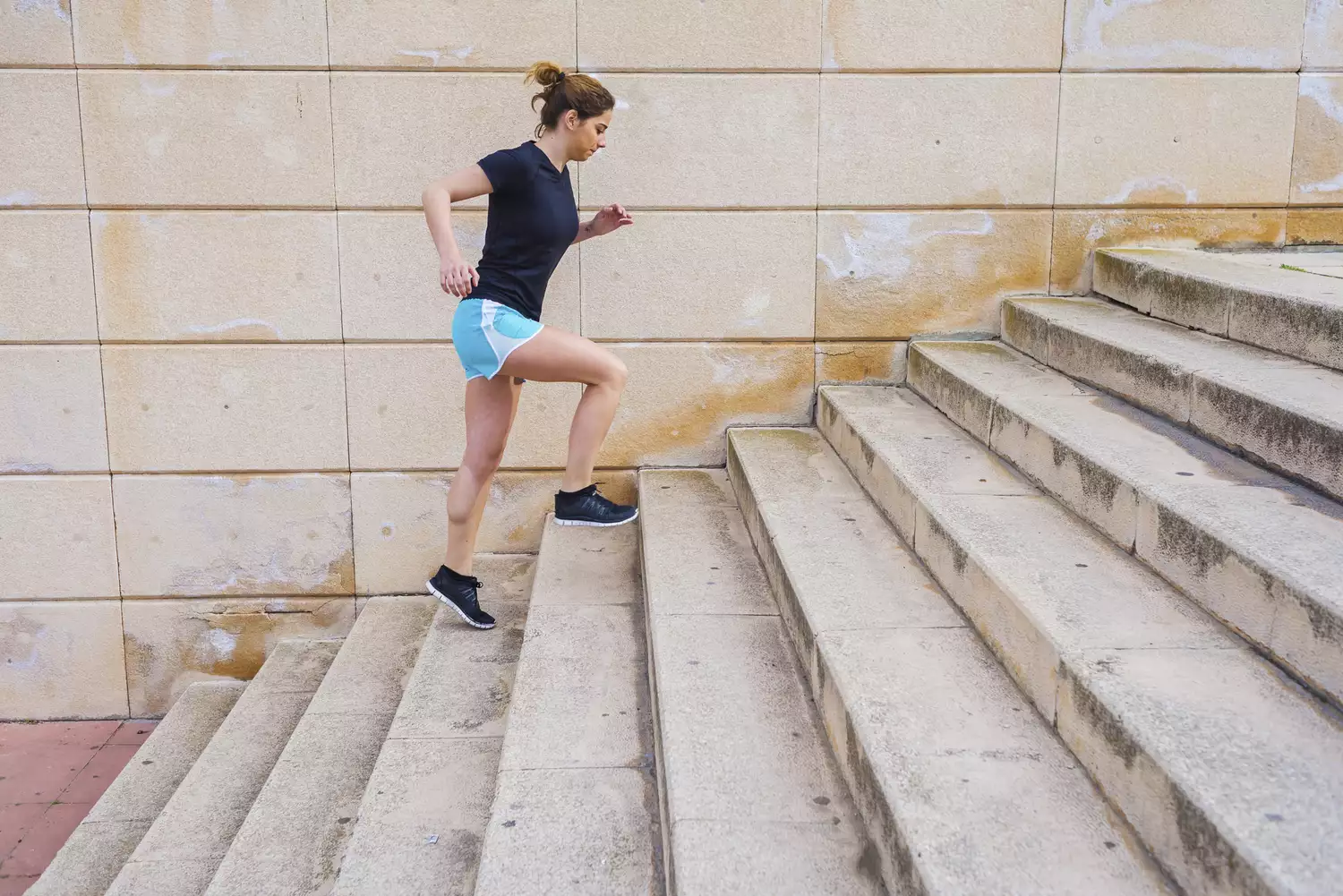 A person runs up outdoor stairs, displaying stamina