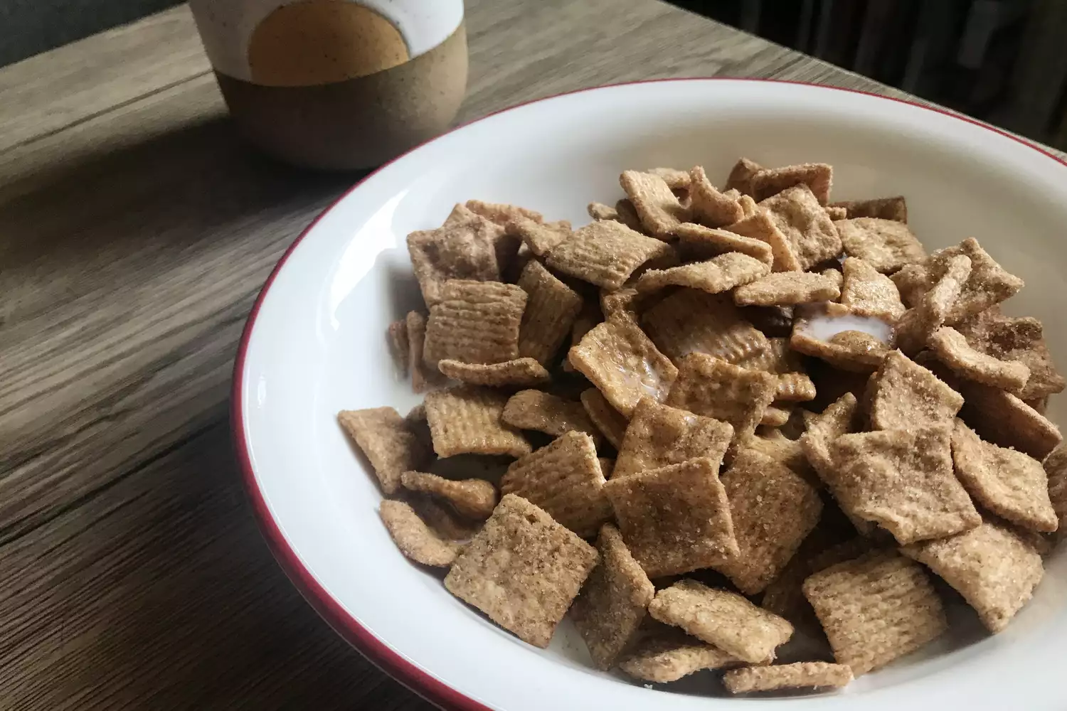 A bowl of Cinnamon Toast Crunch cereal with milk.